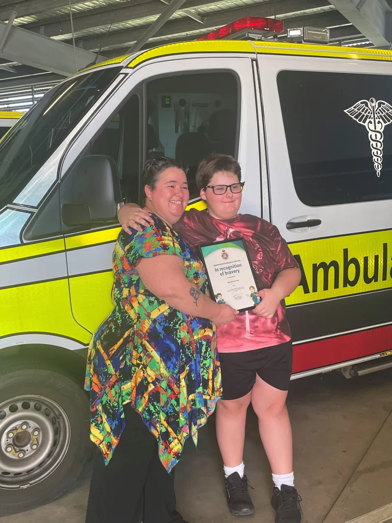 Photo of mother and son receiving bravery award after lawnmower accident