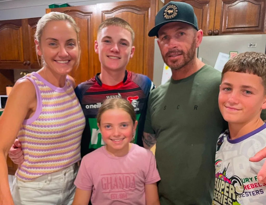 A family portrait of Sarah, Laine and their children Jett, Lucy and Coby. They are standing in the kitchen.