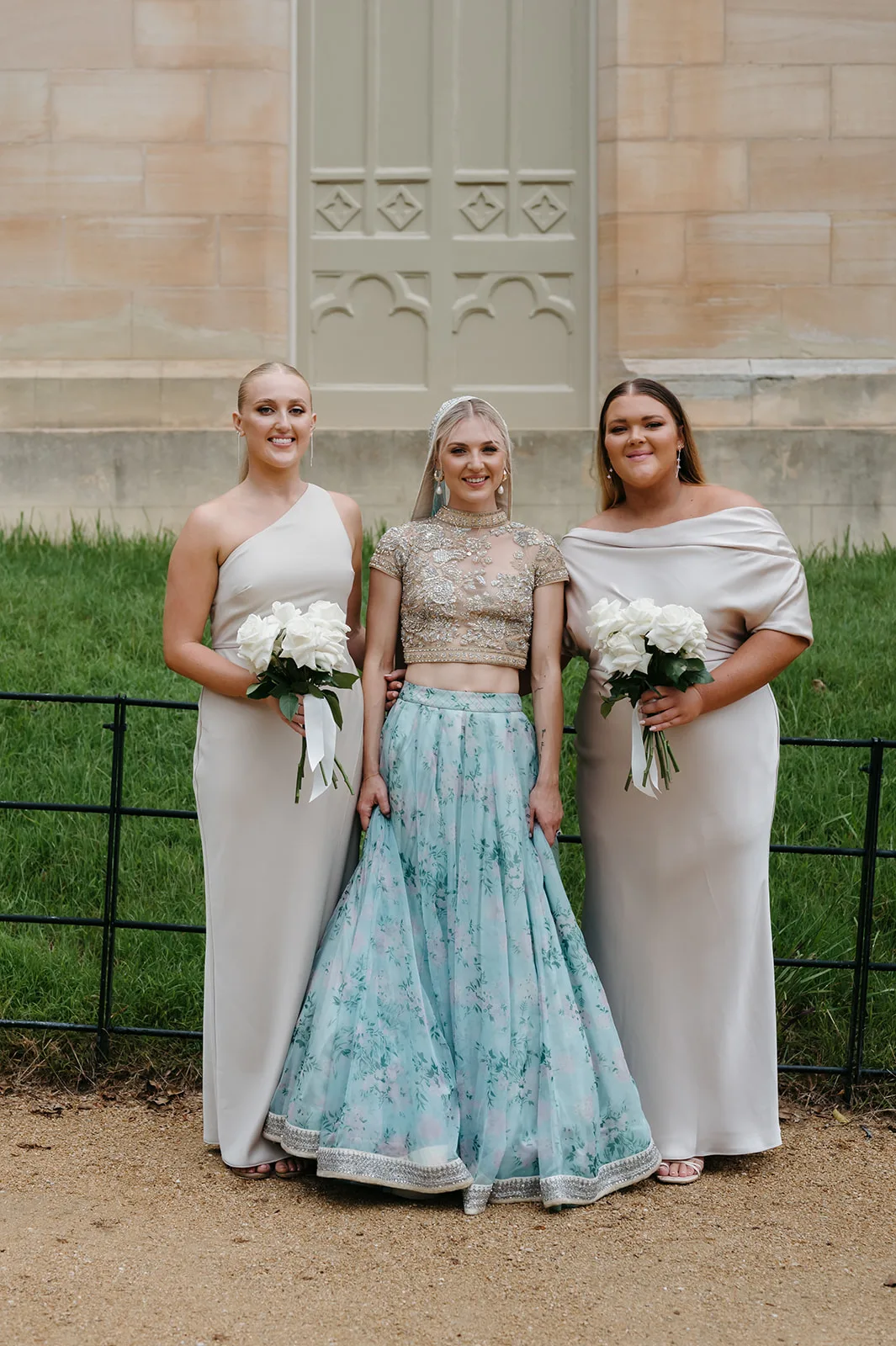 Chloe is wearing a champagne coloured bridesmaid gown, standing alongside her friends