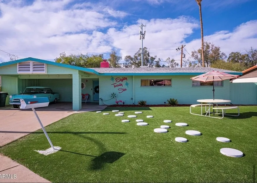 Rochelle's 50s style home is painted blue and green. Her vinatge blue car is parked in the driveway