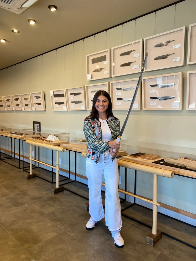 Image of woman holding a traditional japanese samurai sword as part of a Gifu travel guide