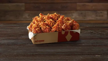 Man eating Red Rooster fried chicken