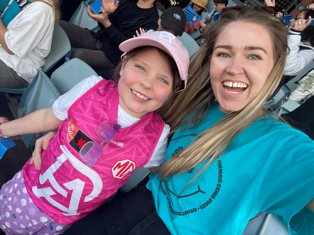 Image of mum and daughter at an AFL game