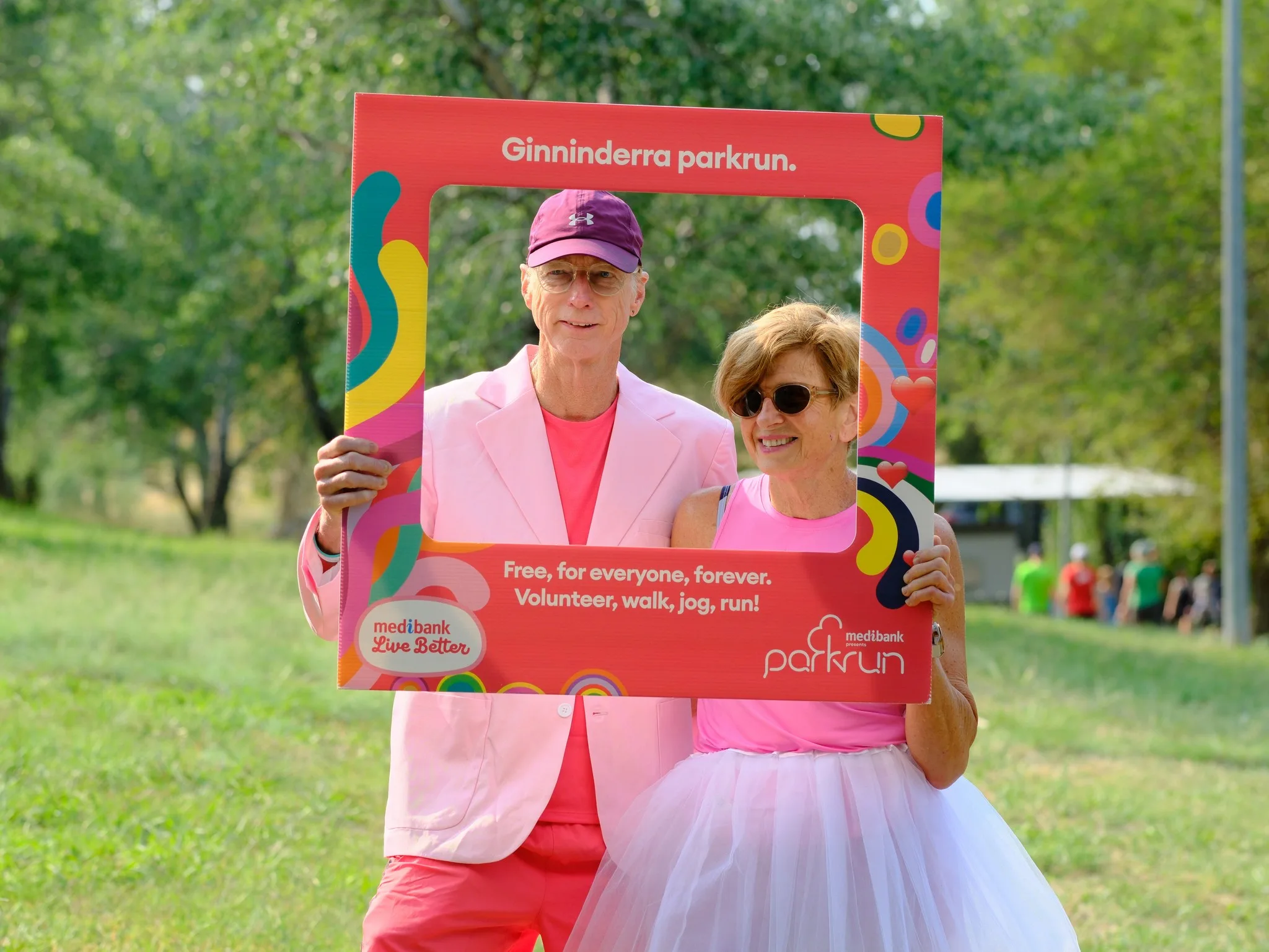 man and woman holding photoframe dressed in pink