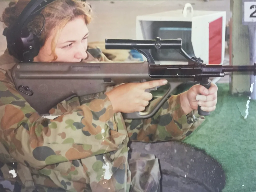 Missy in the army. She's wearing her uniform and holding a gun.