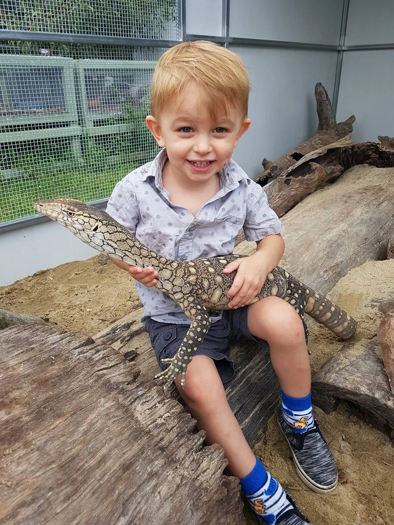Jensen as a toddler holding a reptile.