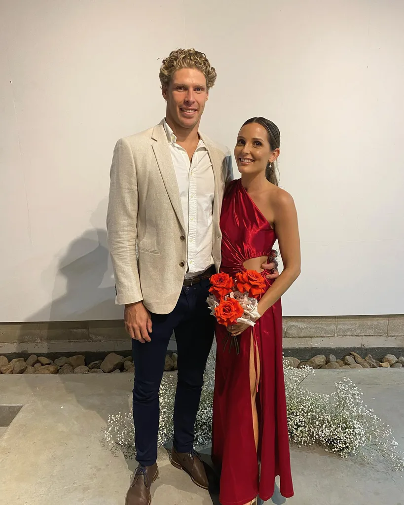 Image of man wearing grey suit and woman in red dress