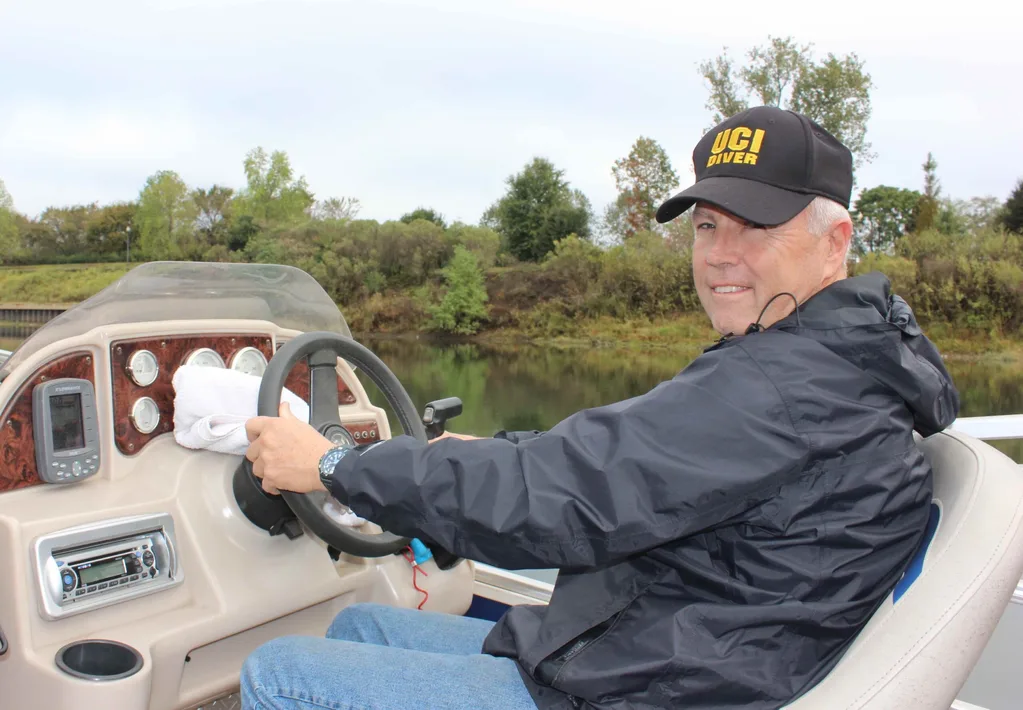 Image of underwater detective driving boat