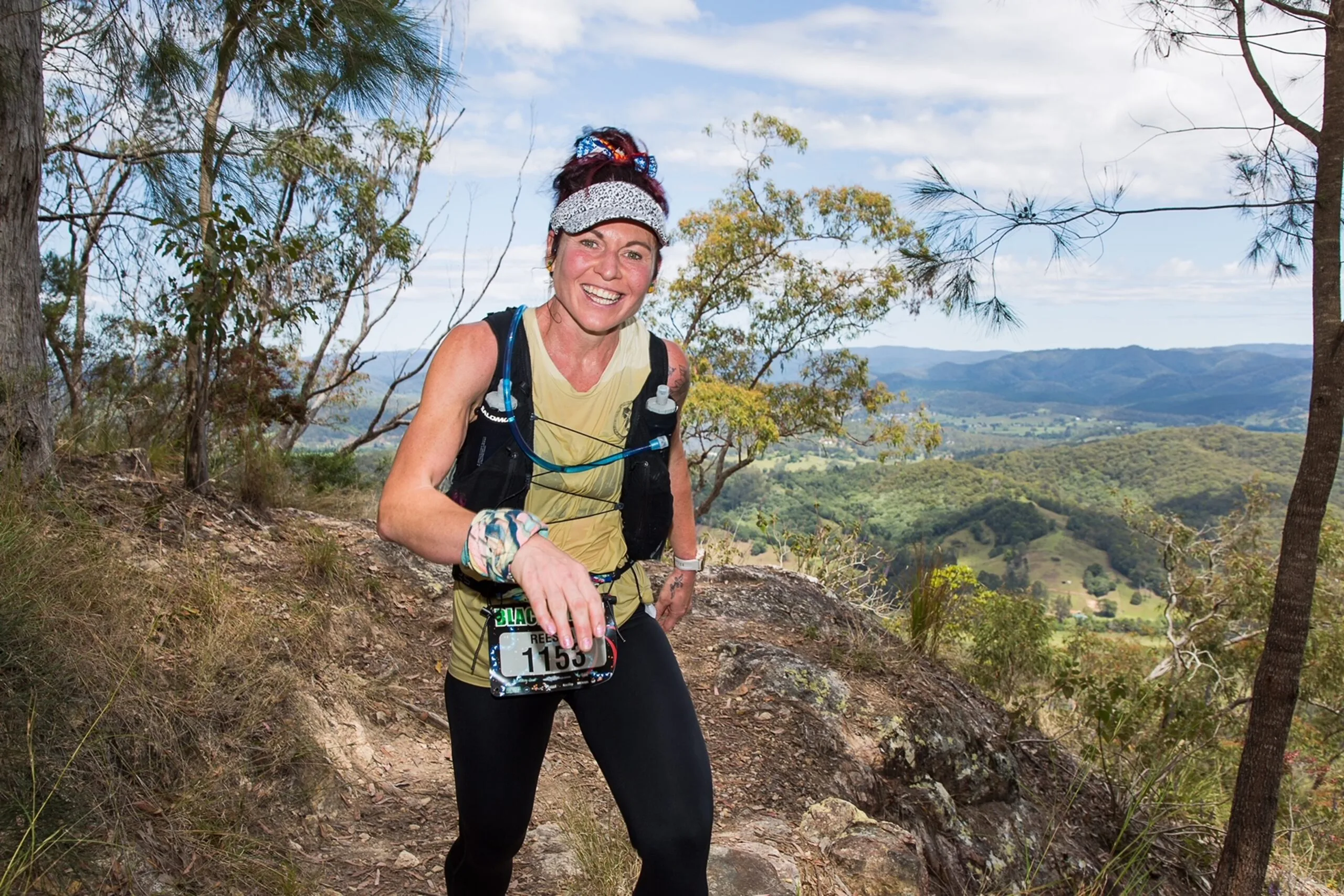 woman in running gear outside on top of a hill