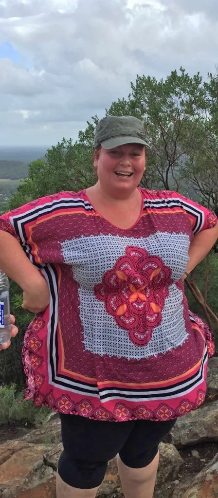 Woman in red and white top with hat on outside