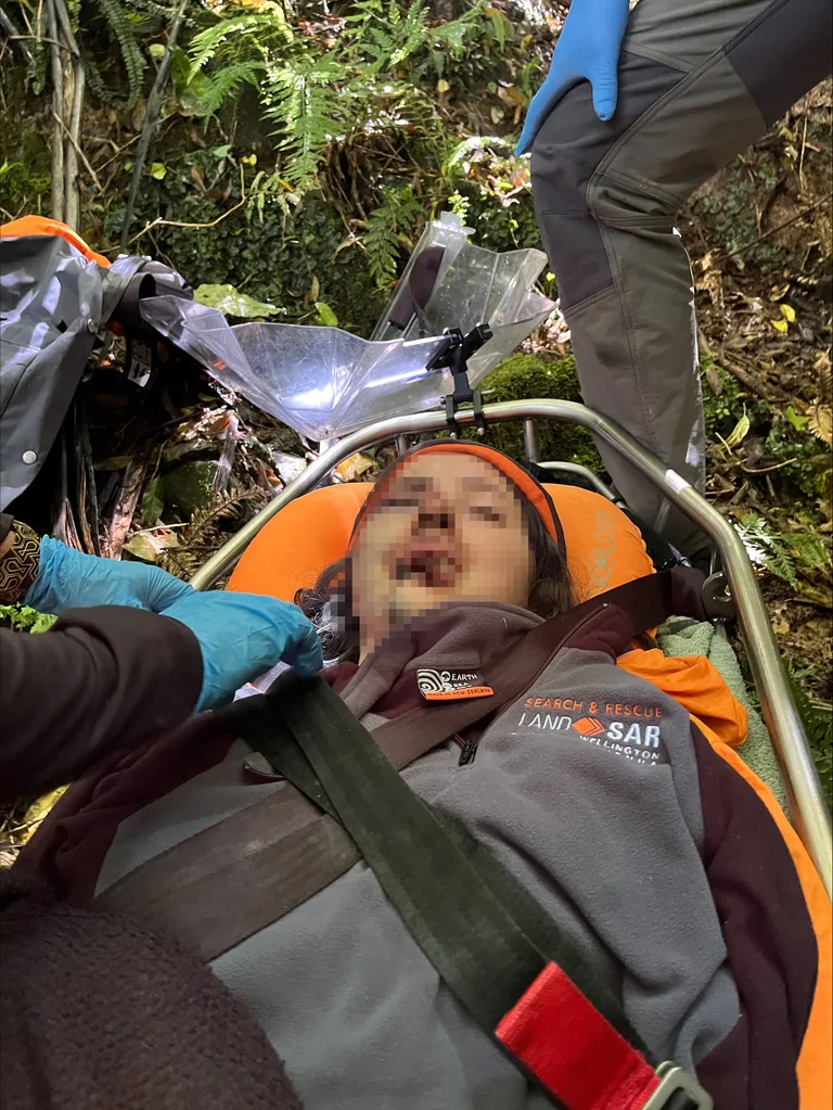 Image of woman laying on a stretcher after being rescued from the bush