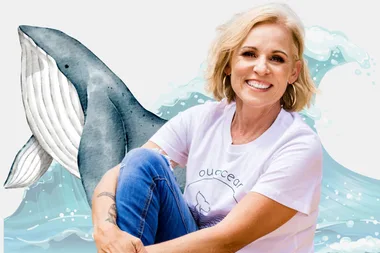 Carmen Ellis sitting on the beach, smiling at the camera