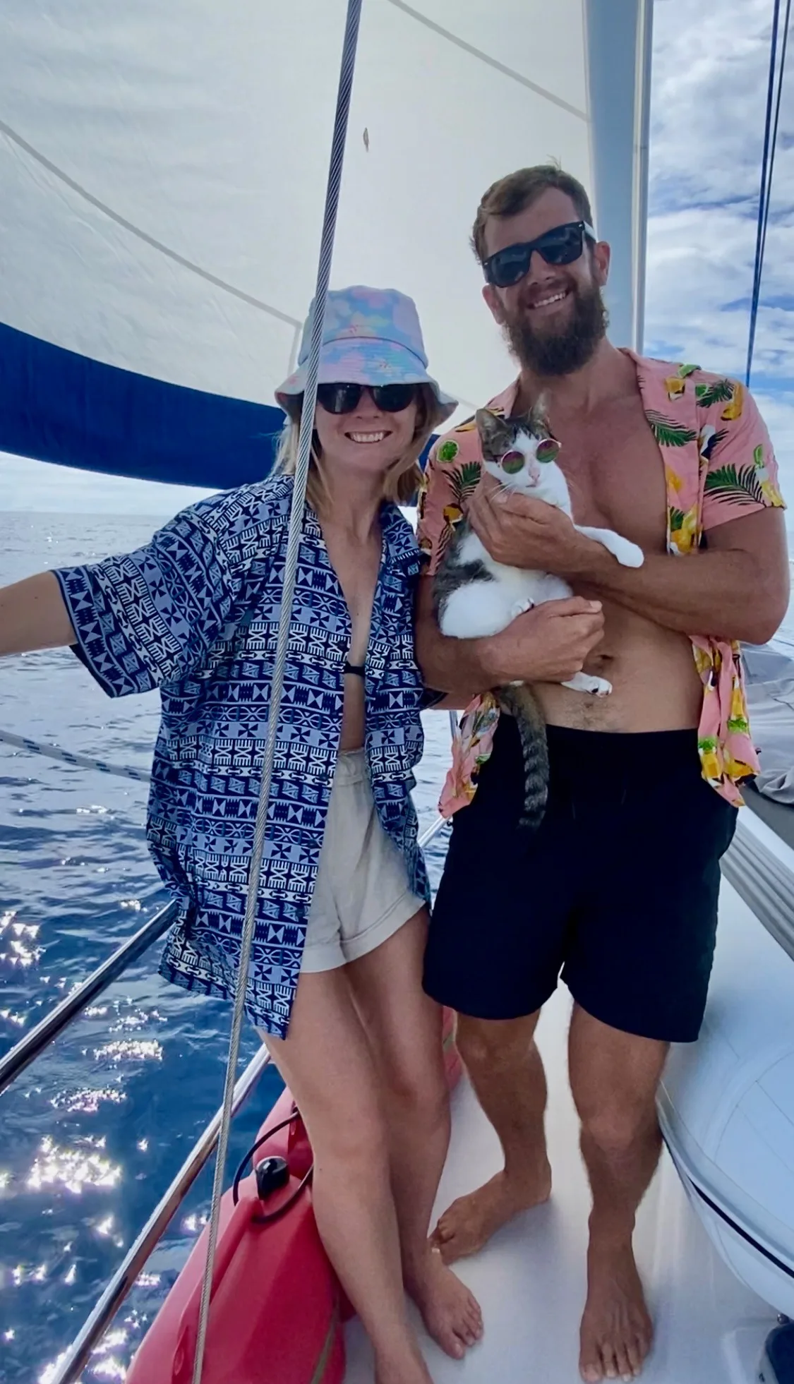 man and woman cuddle cat on boat