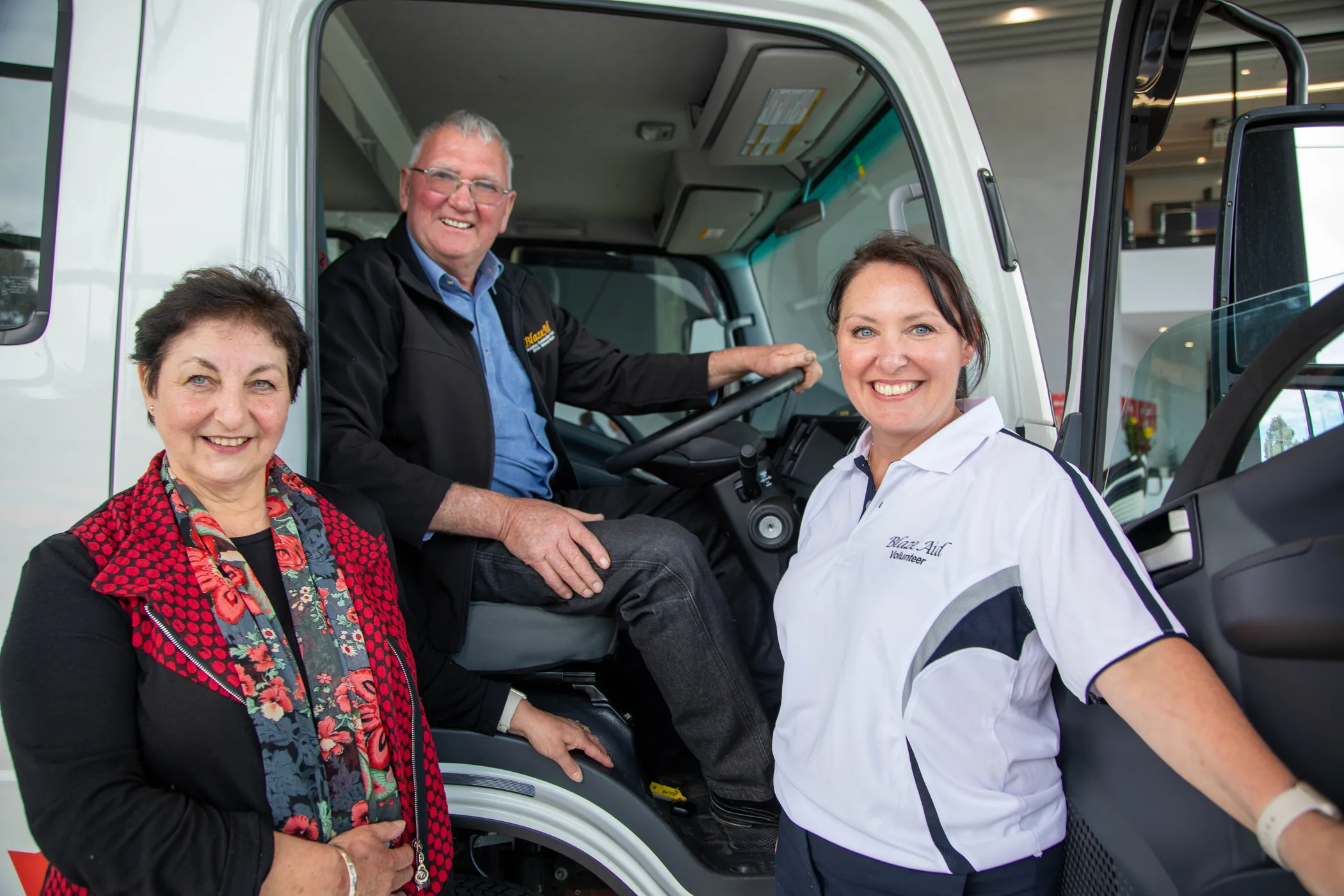 man sitting in truck with woman on left and right