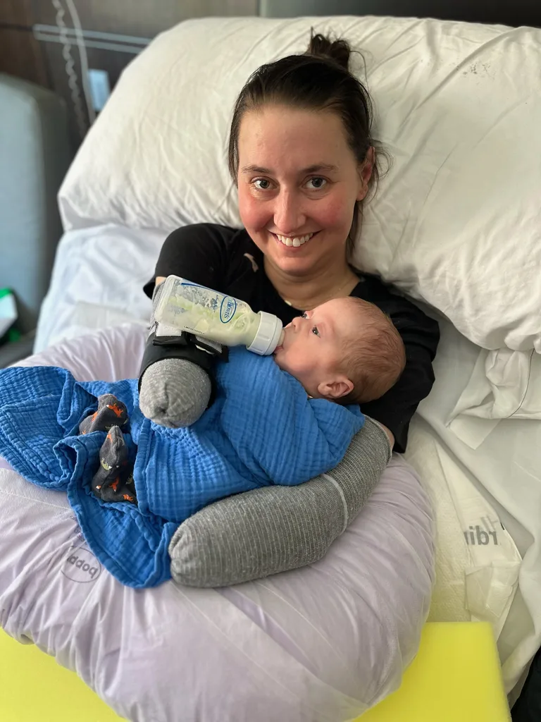 Image of woman with no arms holding her newborn son