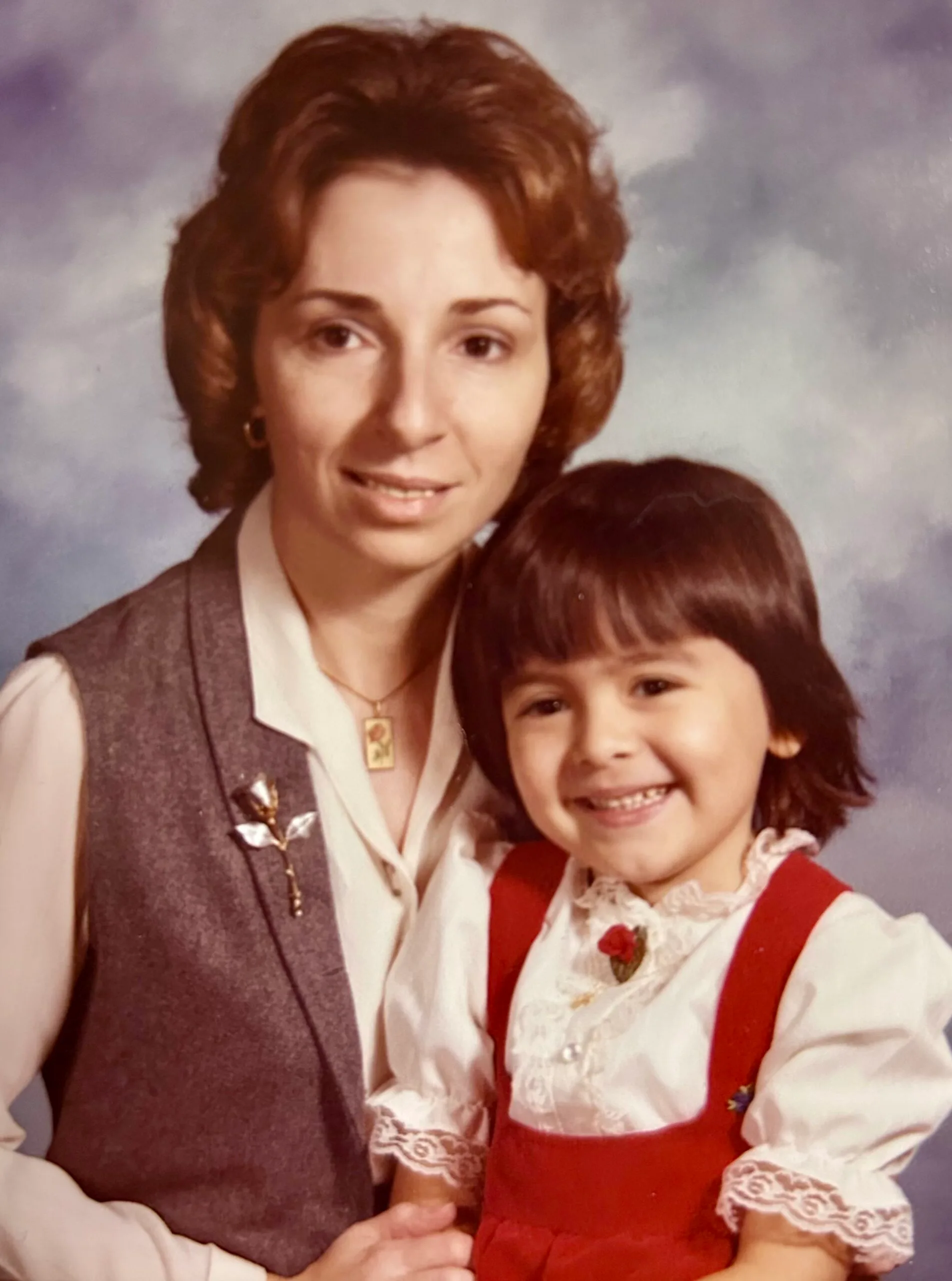 Woman in grey coat with younger girl in red dress