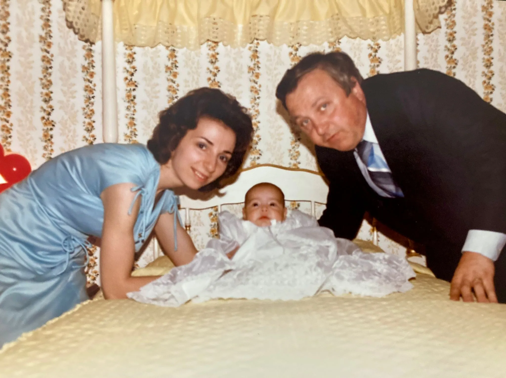 woman and husband posed with baby on the bed