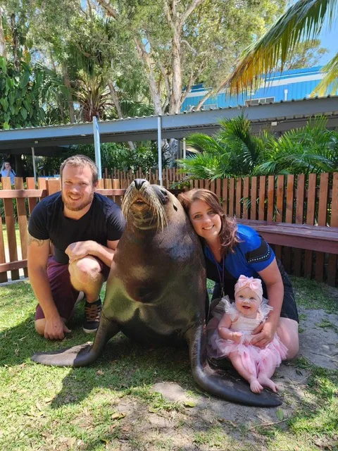 Image of parents and little girl with seal