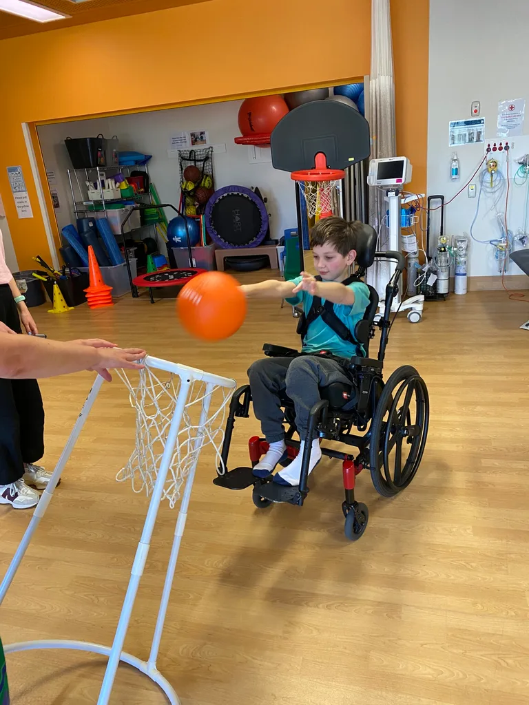 Image of young boy playing wheelchair basketball in hospital