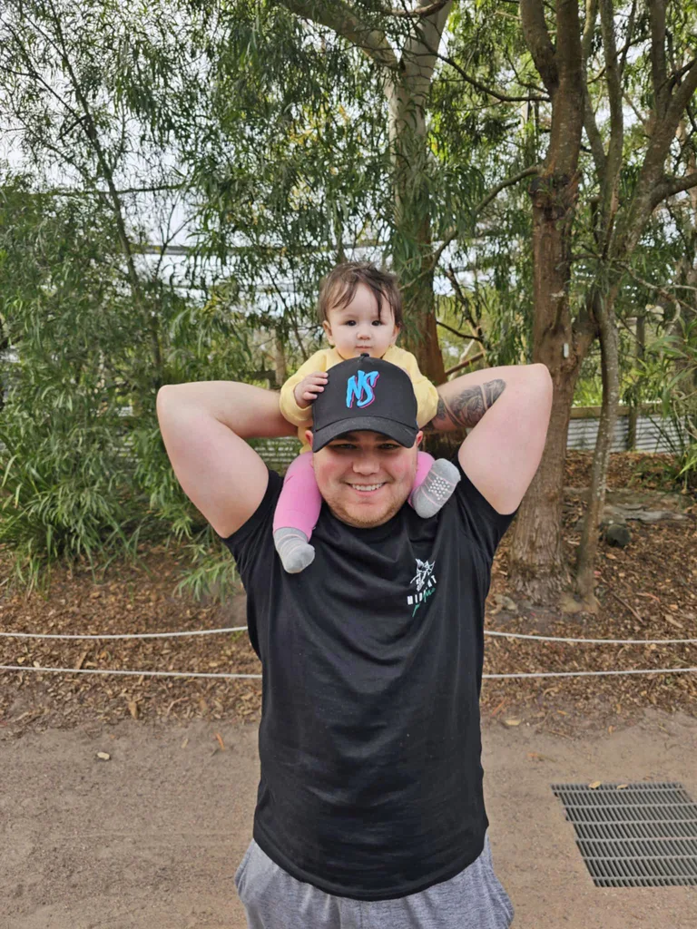 Jake and Lilly. Lilly is on Jake's shoulders and he is smiling.