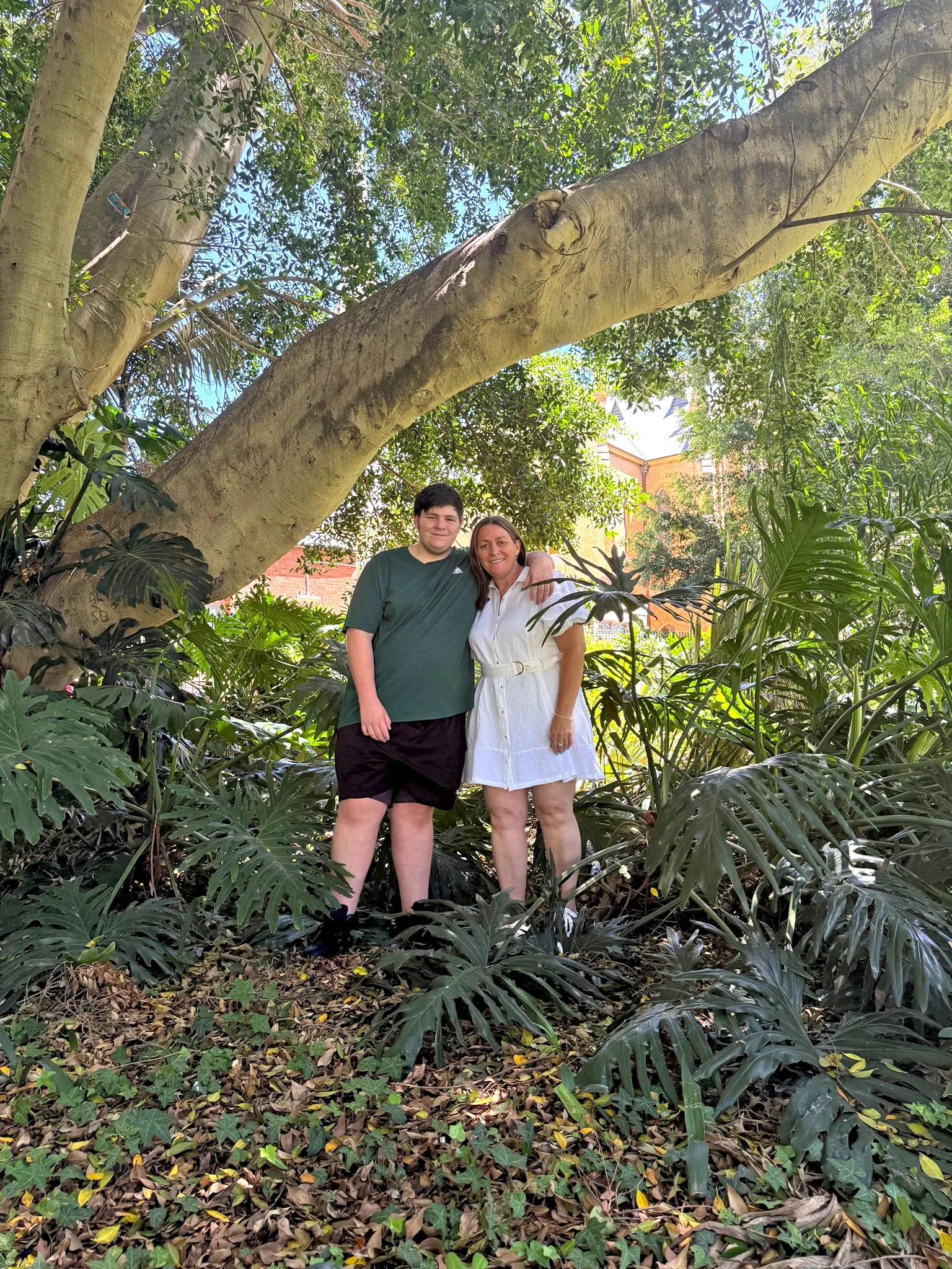 woman and son standing in trees