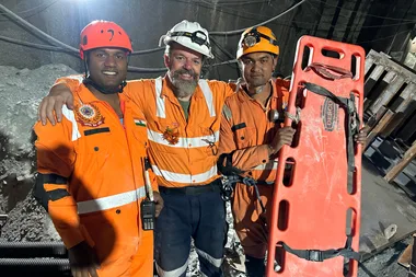 Image of three men wearing orange hi vis during mine rescue