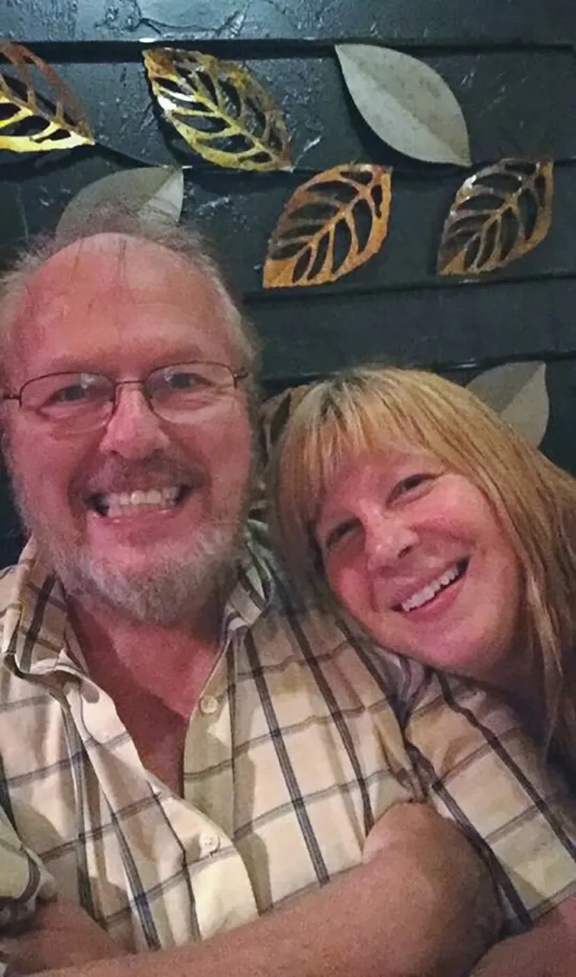 man wearing plaid shirt smiling, woman with fringe also smiling