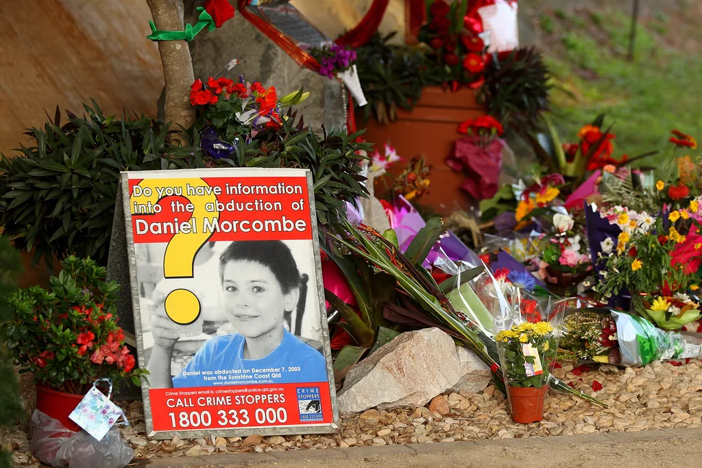 Flowers and a board about Daniel Morcombe in underpass.
