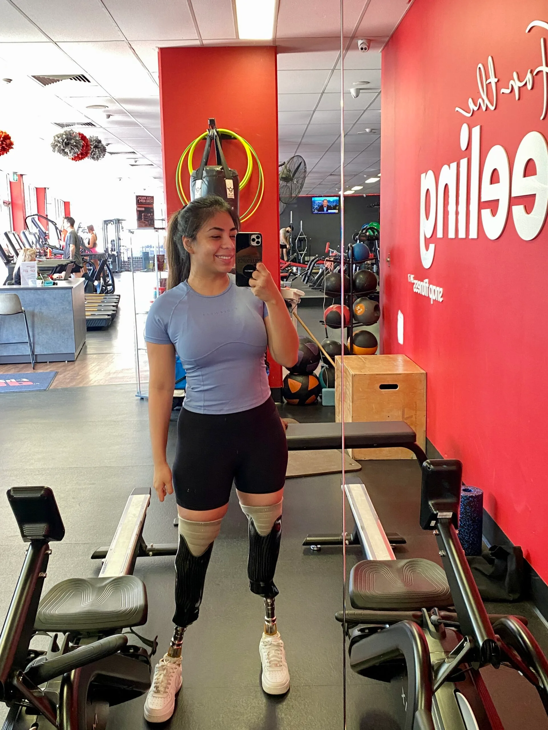 woman standing in gym with prosthetic legs 