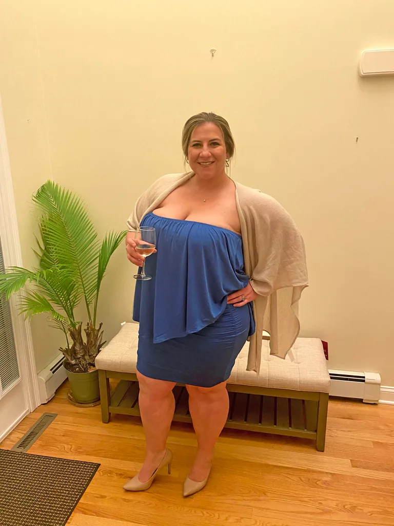 Connie prior to her weight loss journey. She is wearing a blue dress, beige throw and is holding a glass of white wine