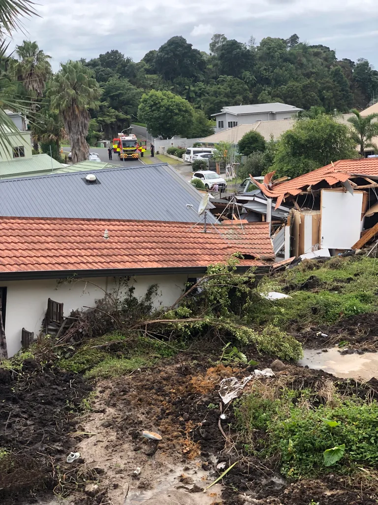 House with red roof under mud and green grass