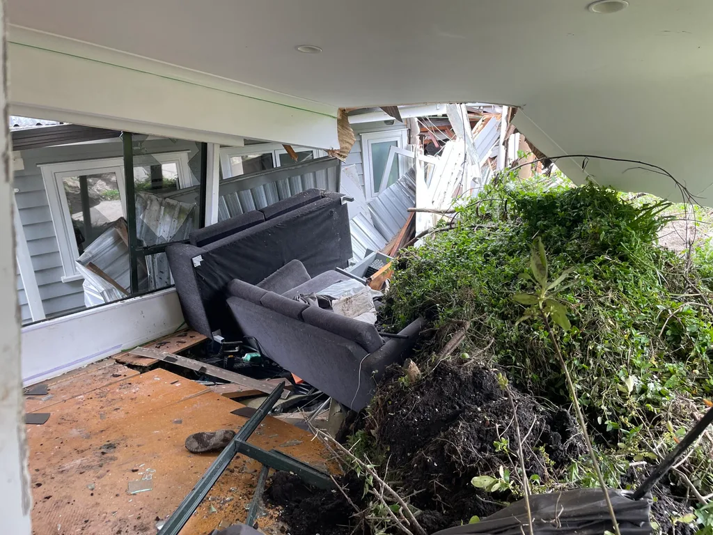 Green grass and mud from landslide in room of house on top of chairs