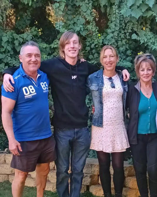 A family photo of Kylie Bailey with her mum, her mum's partner, and her son. They are standing outside and smiling at the camera.