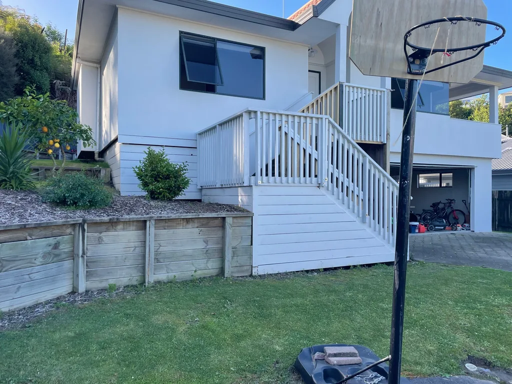 White house with railing and green in front