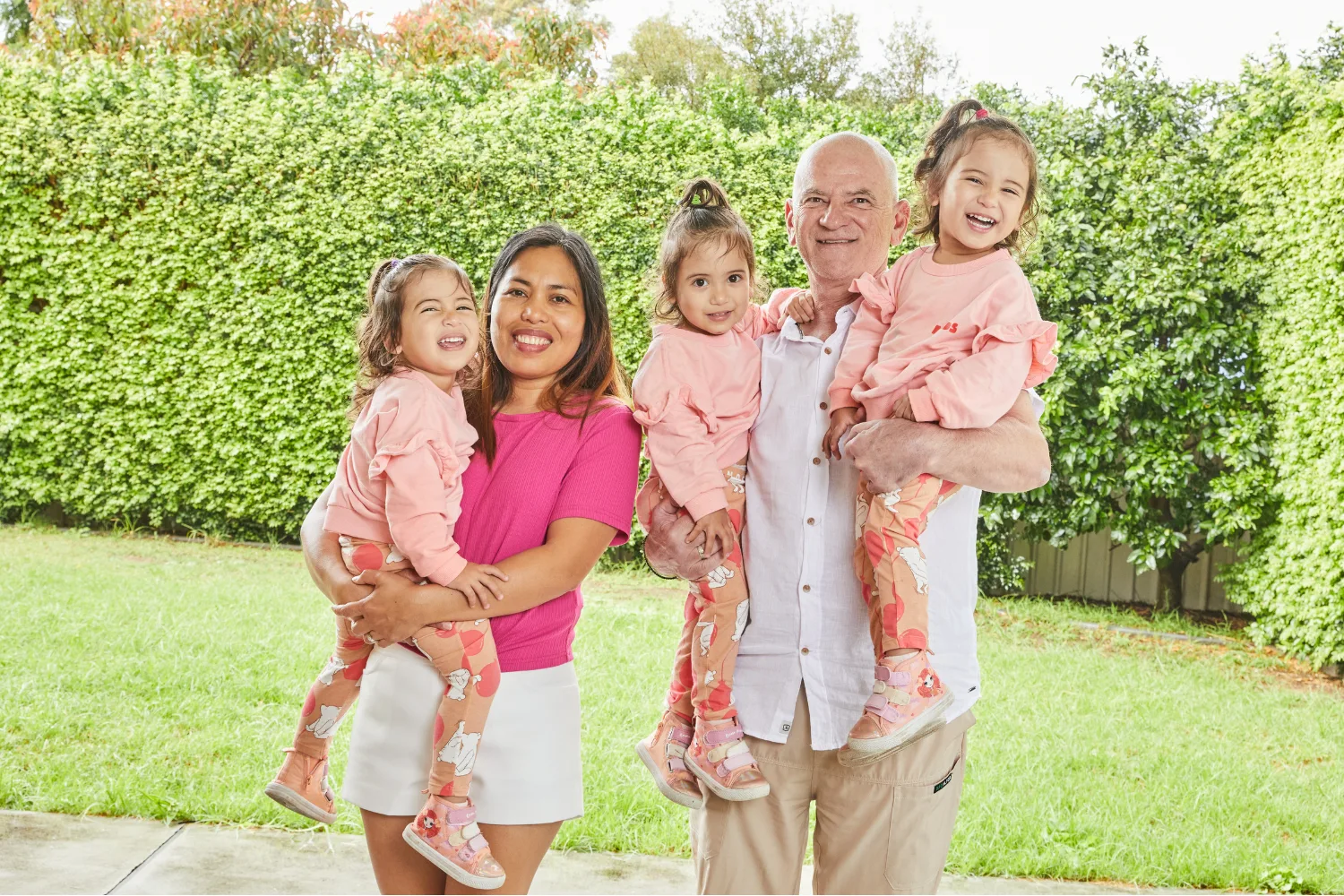 Image of mum and dad holding identical triplet girls