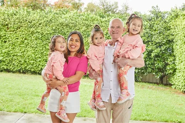 Image of mum and dad holding identical triplet girls