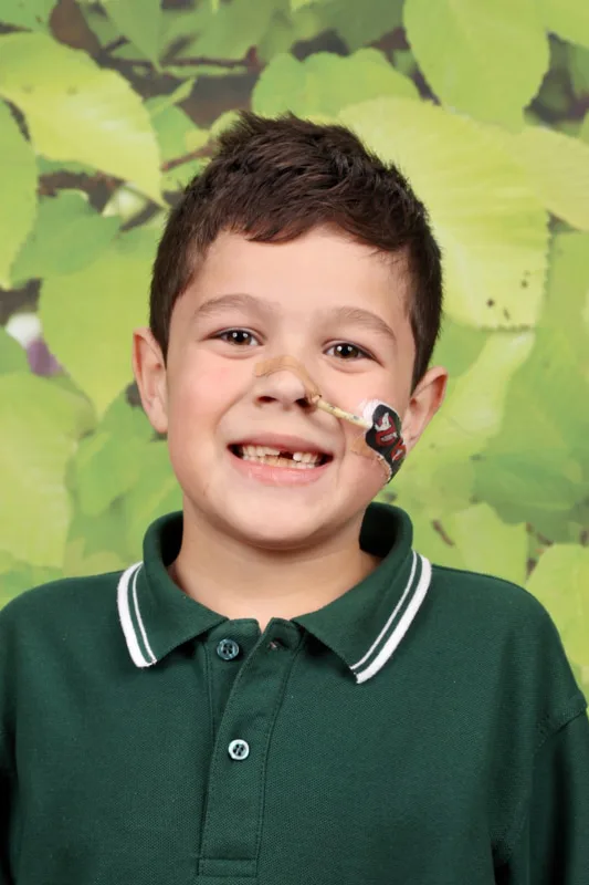 Boy in green shirt against green background.