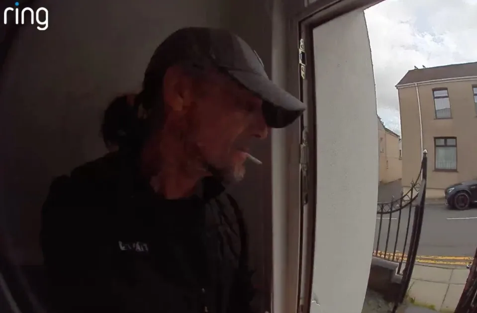 Man in CCTV footage wearing a grey cap and black top