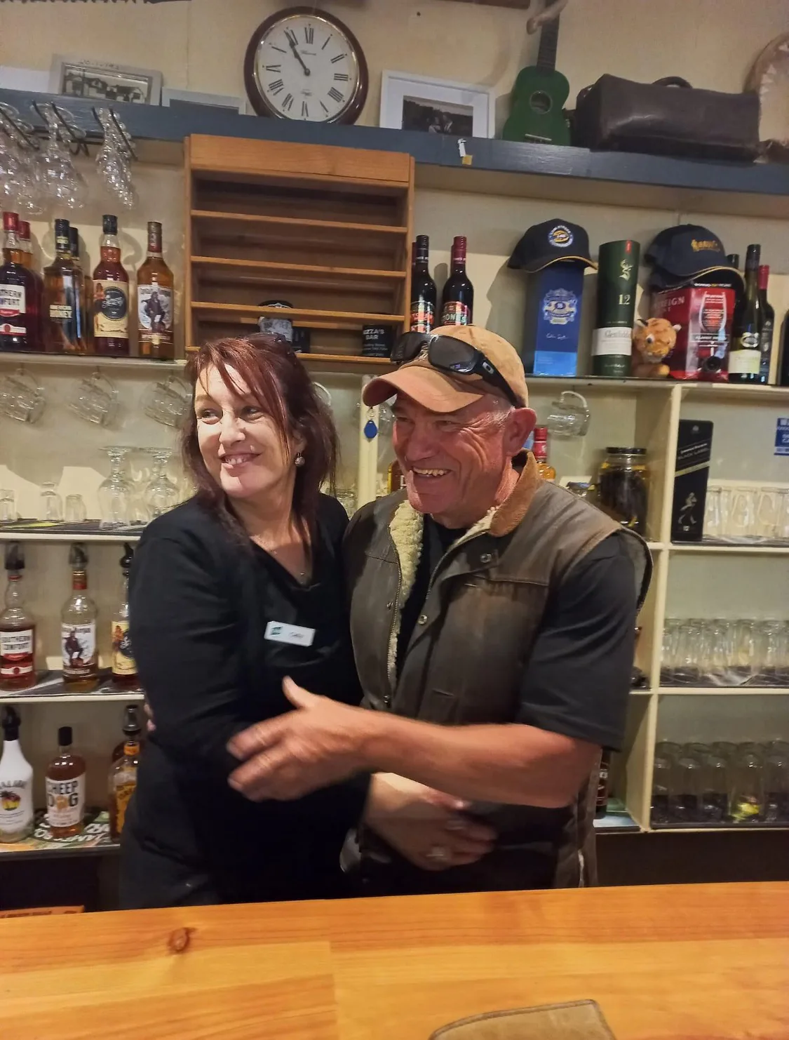 woman and man in black standing behind a bar