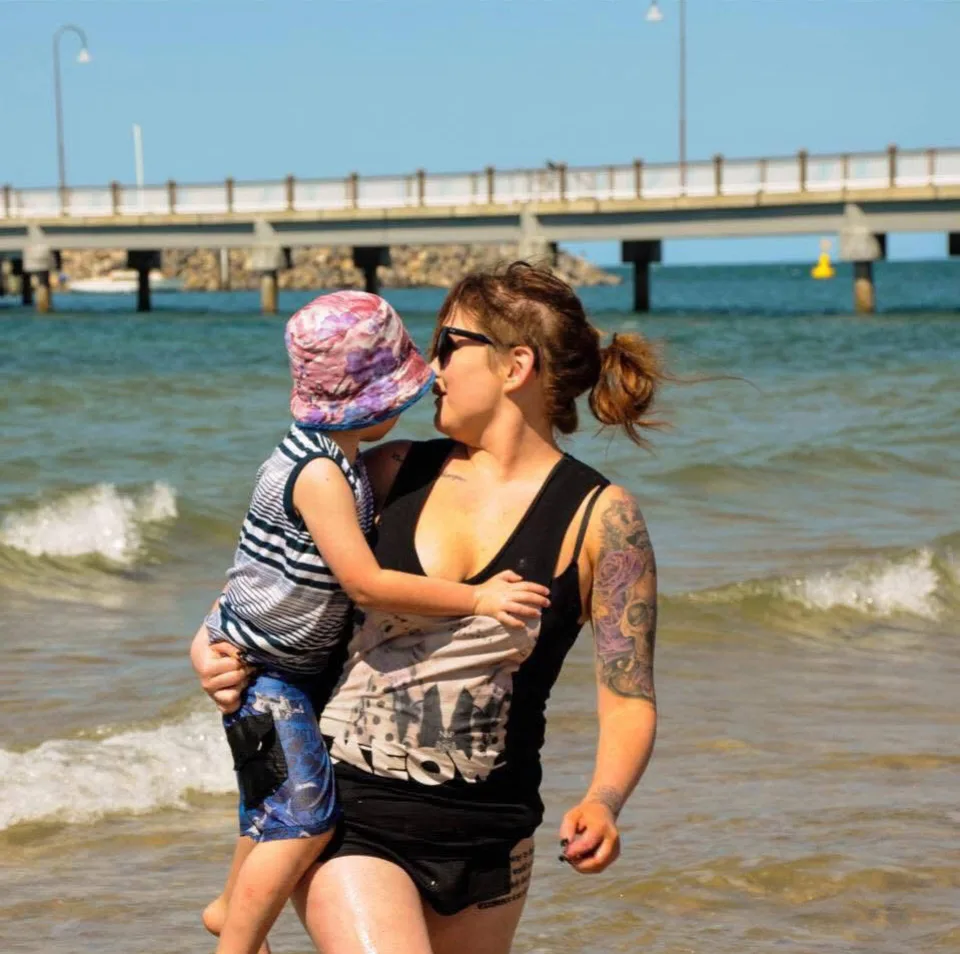 Image of woman holding son at the beach