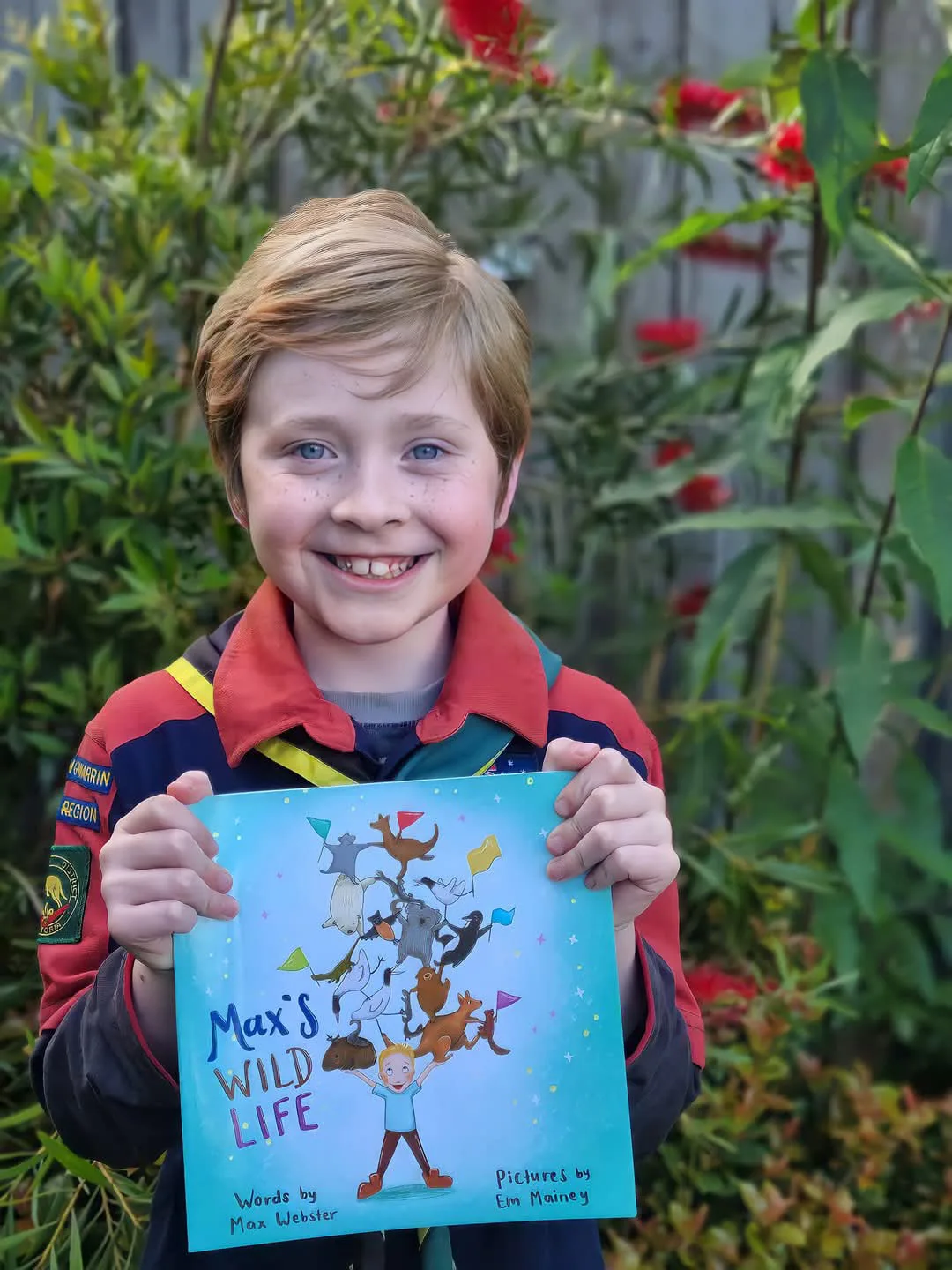 Boy holding a blue book with title Max's Wild Life 