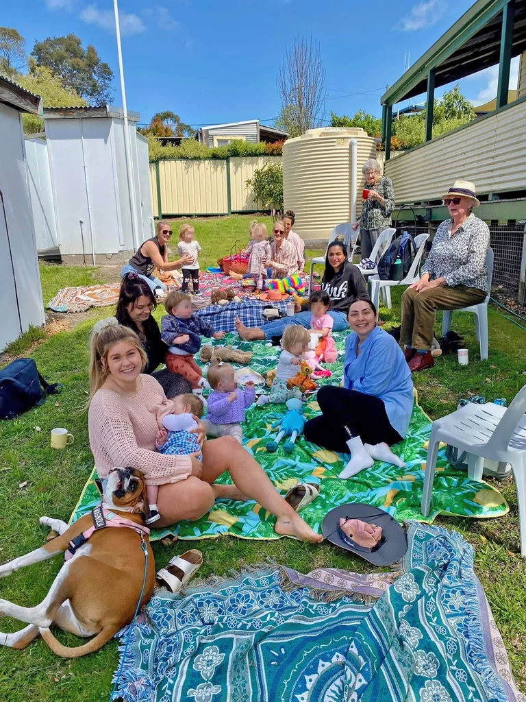 Image of mums and babies sitting on playmats in the backyard.