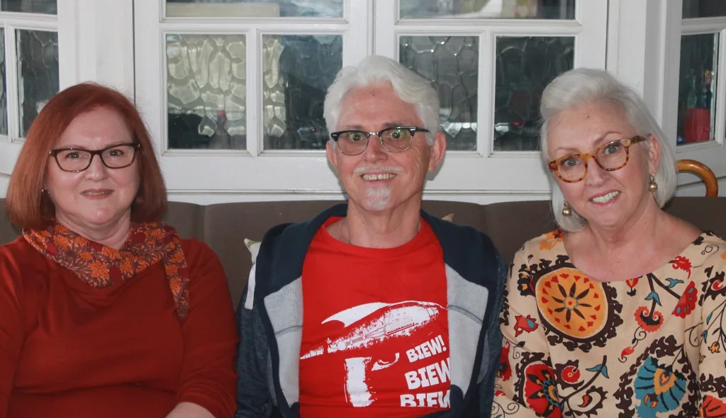 A recent picture of siblings Amanda, Mark and Sue-Ellen sitting on the couch and smiling.