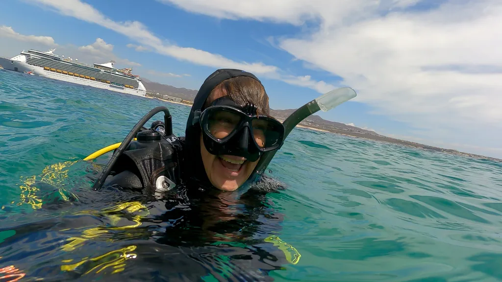 Image of woman scuba diving smiling wearing snorkel
