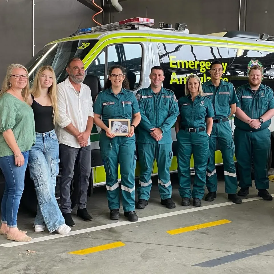Image of man standing with team of paramedics that saved his life