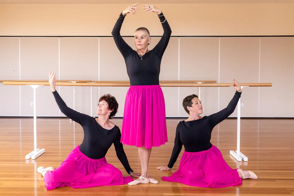 Three middle-aged women posing in ballerina costumes