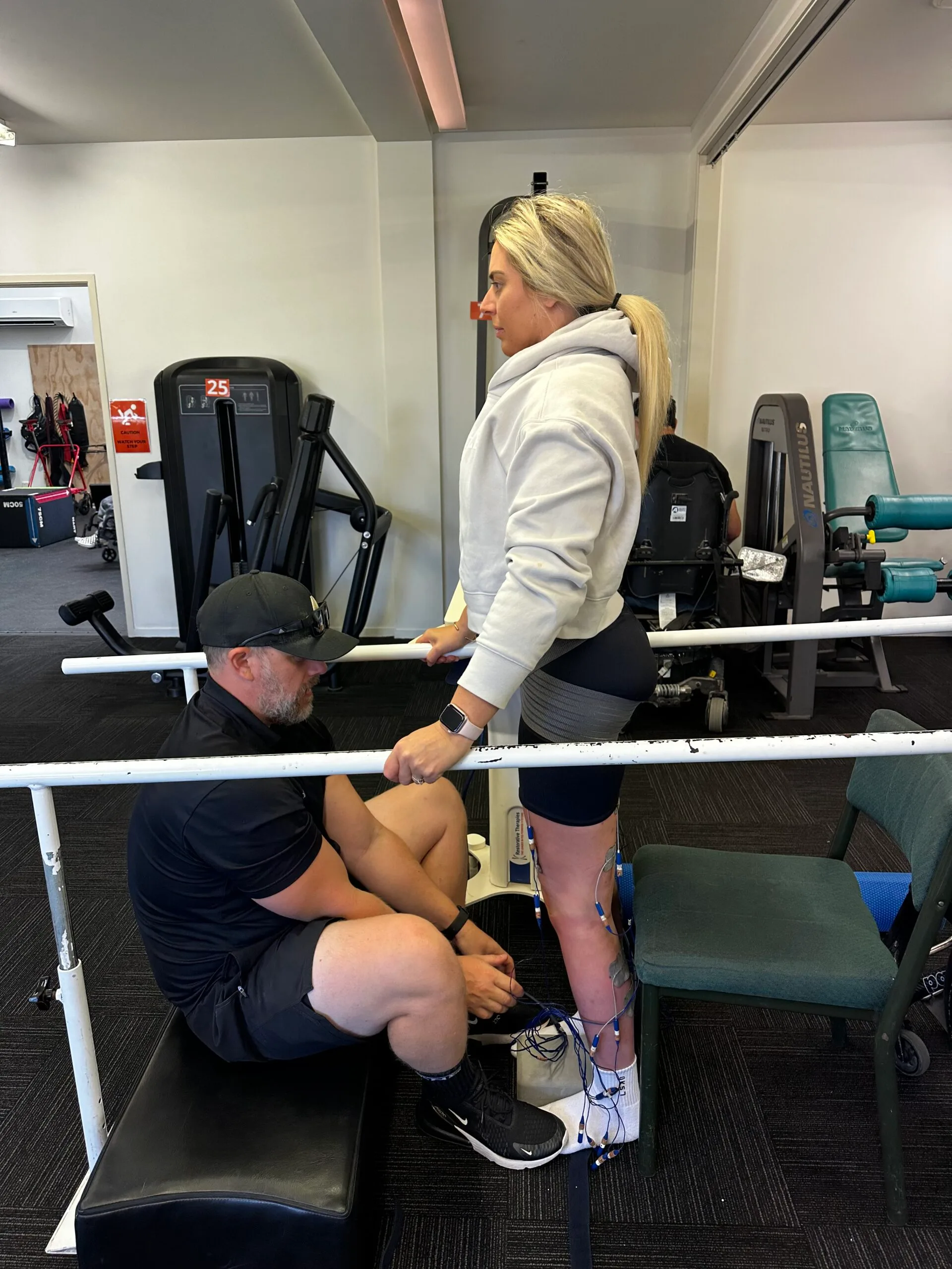 woman doing rehabilitation with electrodes connected to her legs