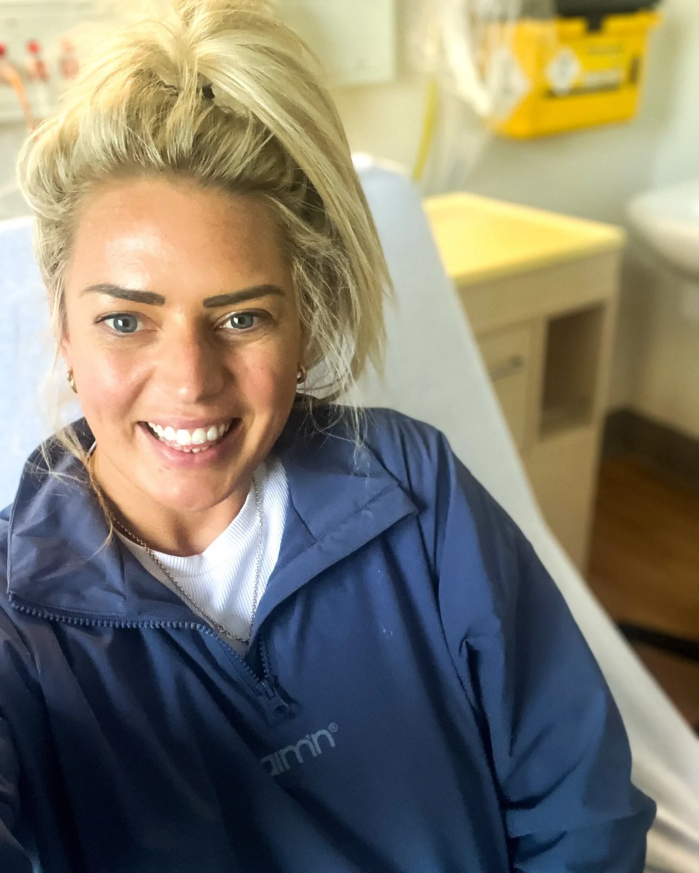 smiling blonde woman in navy jacket