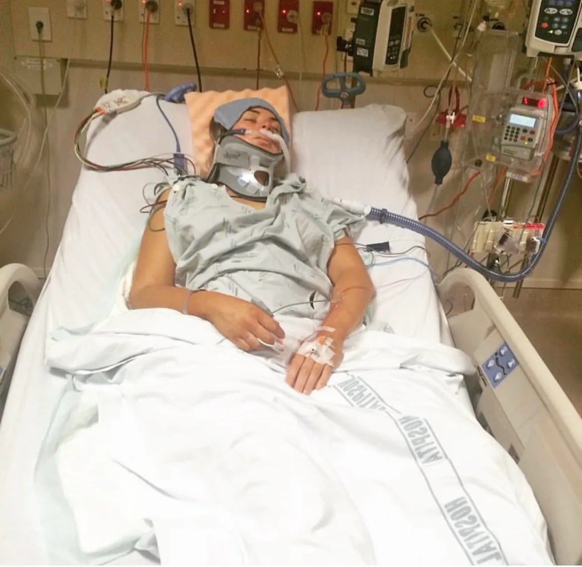 woman unconscious in hospital bed with head and neck brace
