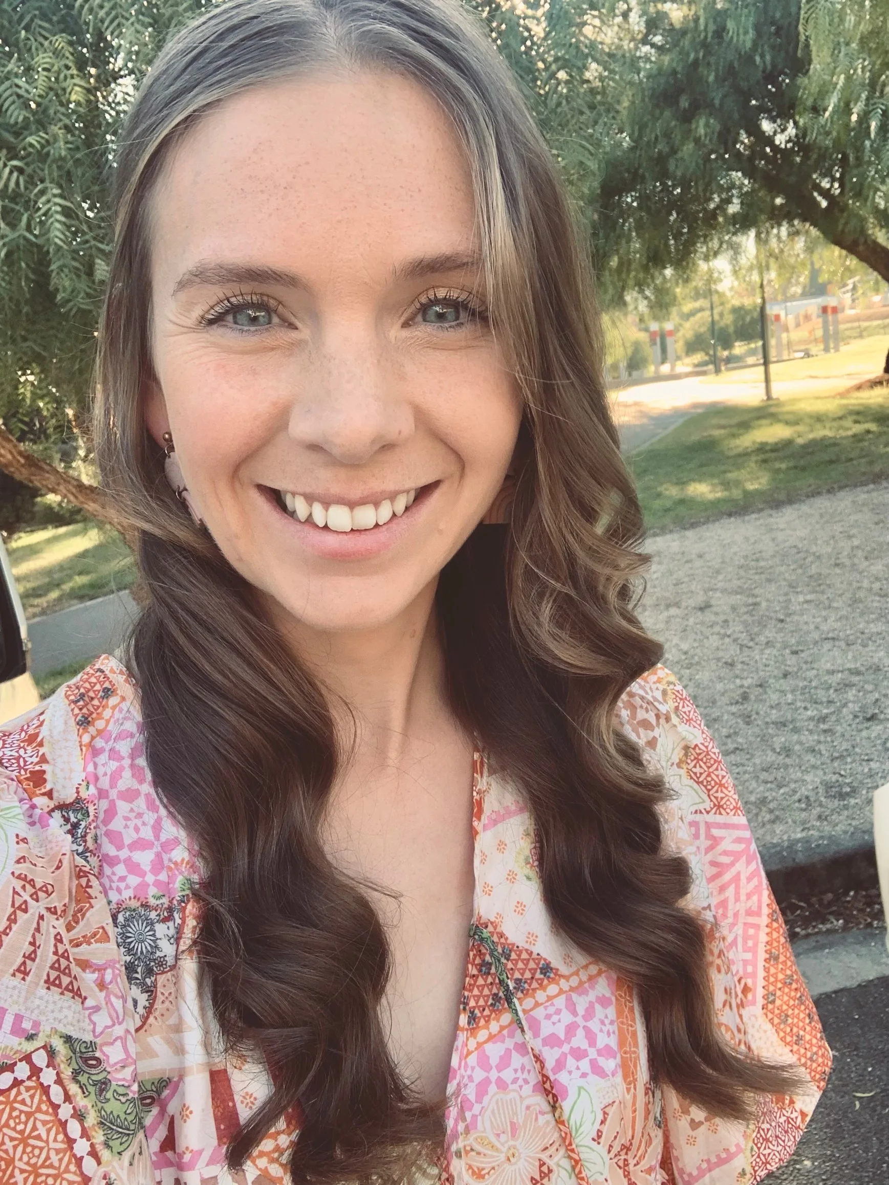 woman in flower dress with long hair standing outside